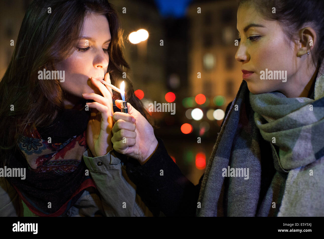 Woman lighting friend's cigarette Stock Photo Alamy