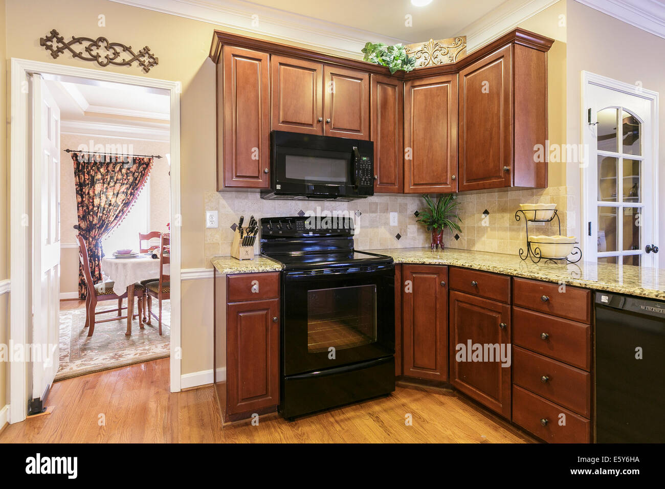 Custom kitchen in traditional home featuring hardwood floors and cabinets. Stock Photo