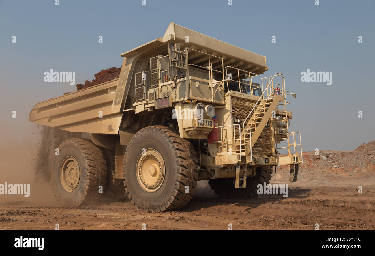 A white 200ton payload Hitatchi Diesel/ Electric hybrid hauls waste in a large open cast copper mine in Africa. Stock Photo