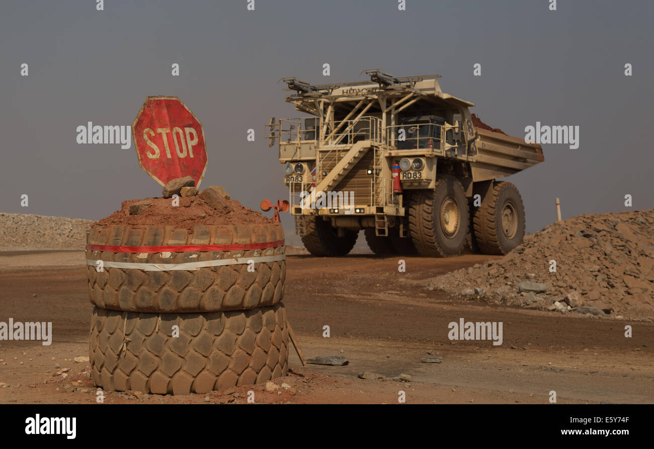 A Hitatchi mining truck drives past a stop sign in a massive open cast copper mine in Zambia, Africa Stock Photo