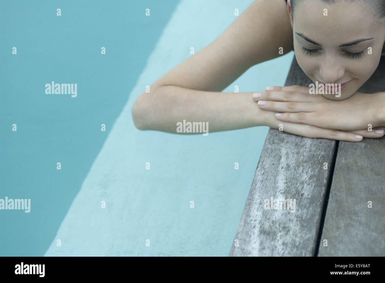 Young woman sunbathing beside pool Stock Photo