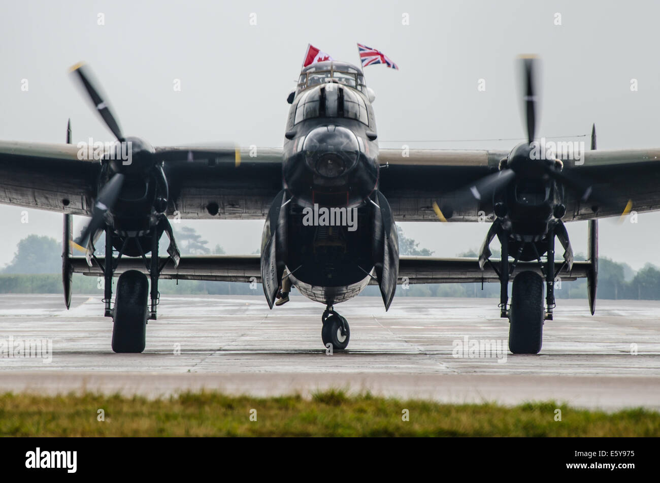 The Canadian Lancaster has made the long flight across the Atlantic to the UK. Seen after landing at RAF Coningsby taxiing in with national flags Stock Photo