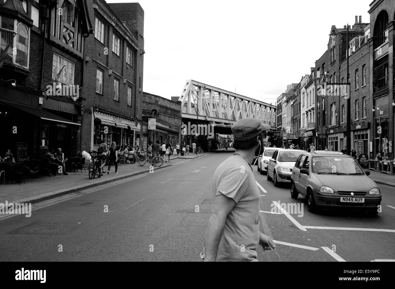 Man crosses road in front of cars in East London Stock Photo Alamy