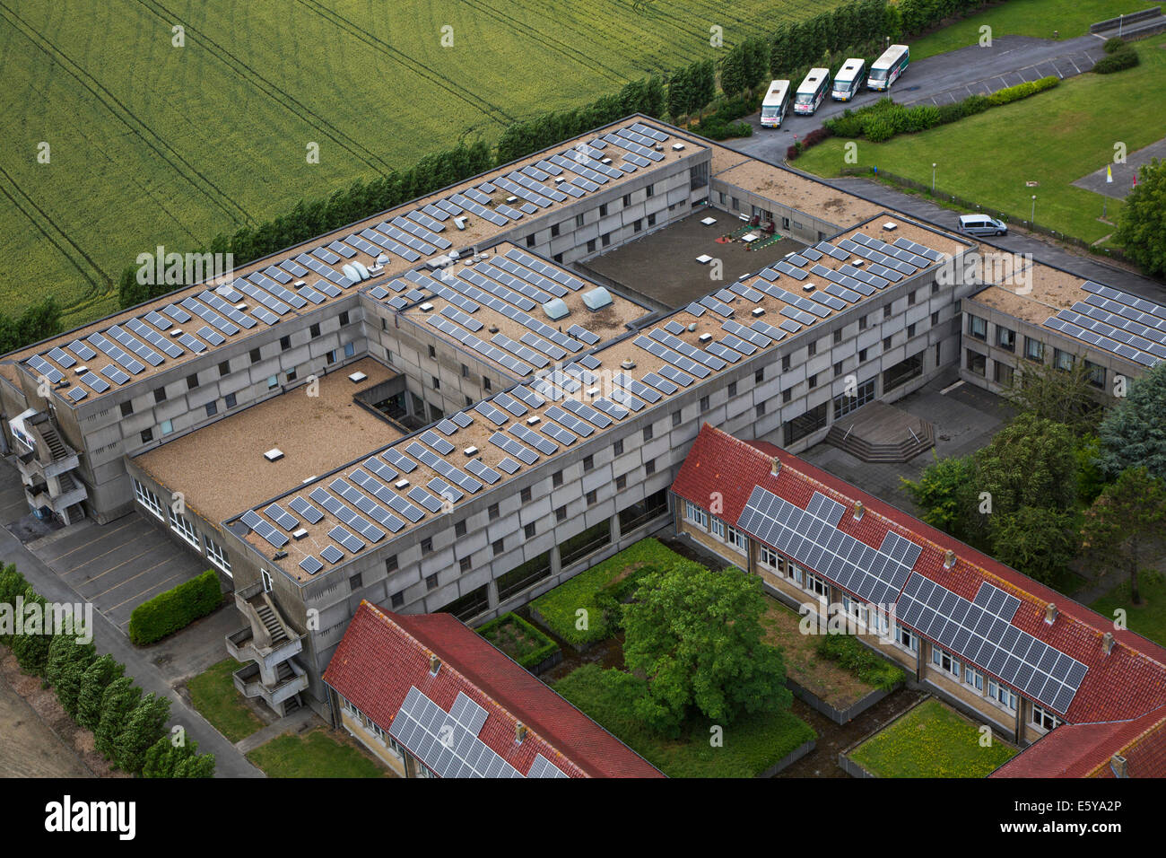 Photovoltaic solar panels on roof providing electricity by sun energy to office buildings Stock Photo