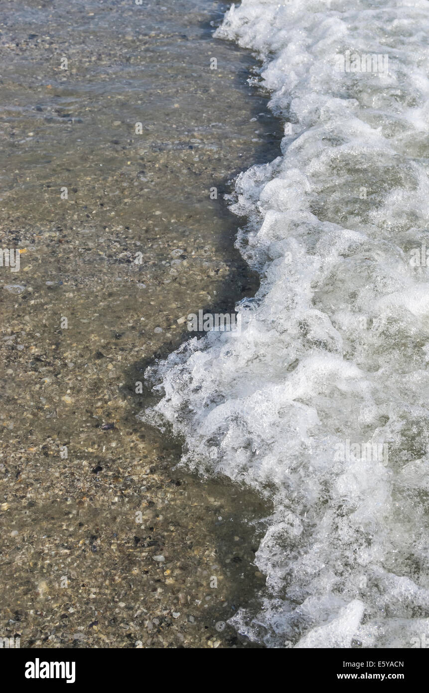 Foam wave splashing on the beach in summer Stock Photo - Alamy