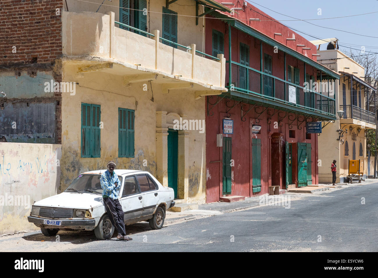 Man resting on car in historic, St. Louis, Senegal Stock Photo