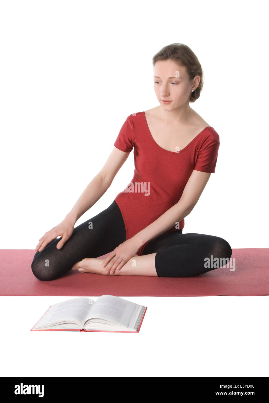 Young woman in sports clothes reading a book Stock Photo