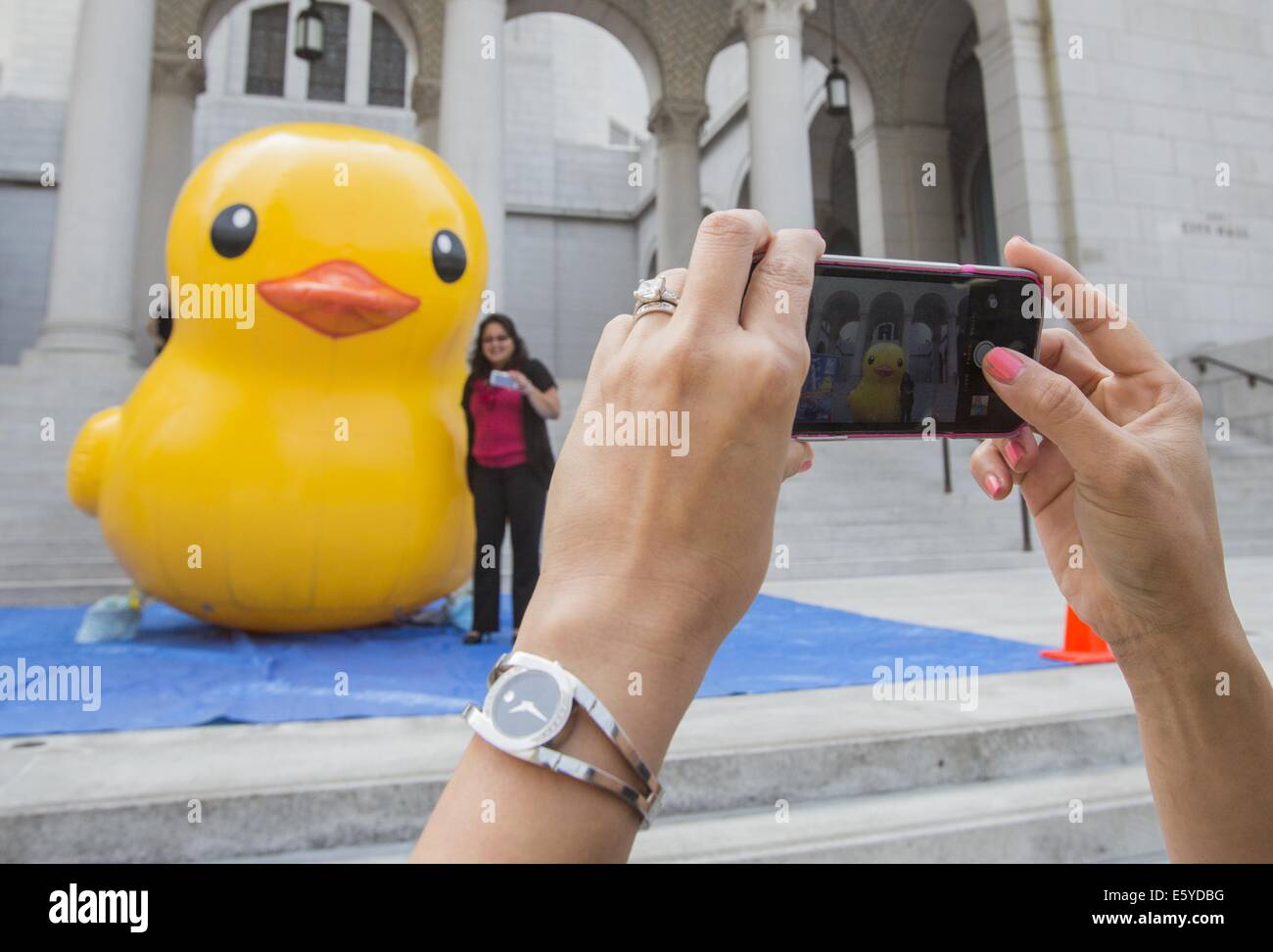 Los Angeles, California, USA. 8th Aug, 2014. People take pictures with a 10-foot-tall rubber ducky ''baby duck'', on the Spring Street steps of Los Angeles City Hall on Friday, Aug. 8, 2014, in Los Angeles. The bright yellow, inflatable ducky is wandering the city in search of its mother, a 60 feet high and dubbed by event organizers as the world's largest rubber ducky as part of a promotional stunt for the Tall Ships Festival taking place Aug. 20-24 at the Port of Los Angeles. Credit:  Ringo Chiu/ZUMA Wire/Alamy Live News Stock Photo