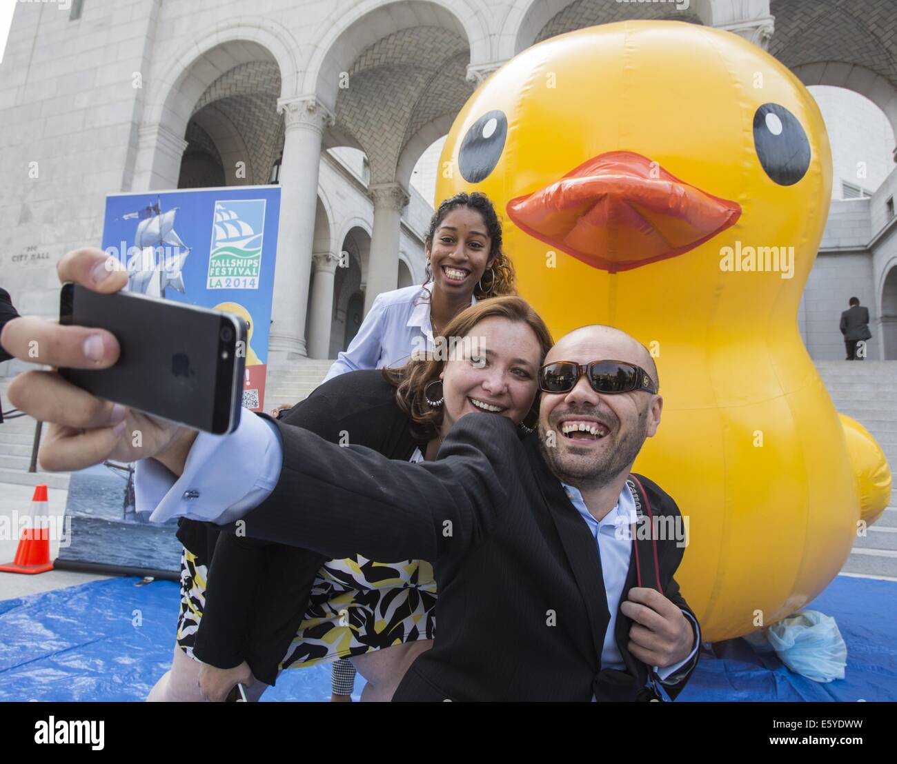 Los Angeles, California, USA. 8th Aug, 2014. Branimir Kvartuc poses with his friends for a selfie with a 10-foot-tall rubber ducky ''baby duck'' squatting on the Spring Street steps of Los Angeles City Hall on Friday, Aug. 8, 2014, in Los Angeles. The bright yellow, inflatable ducky is wandering the city in search of its mother, a 60 feet high and dubbed by event organizers as the world's largest rubber ducky as part of a promotional stunt for the Tall Ships Festival taking place Aug. 20-24 at the Port of Los Angeles. Credit:  Ringo Chiu/ZUMA Wire/Alamy Live News Stock Photo