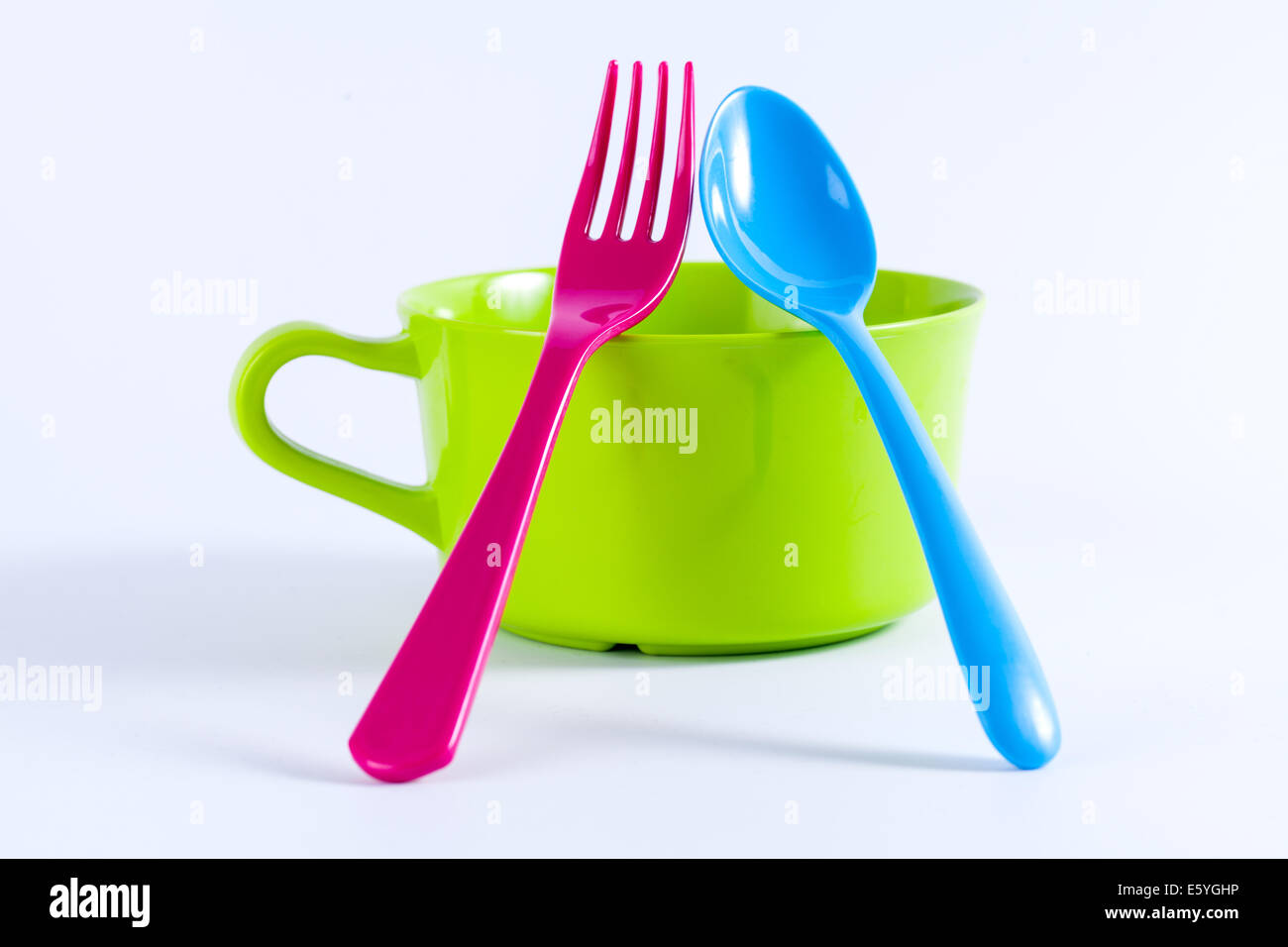 Baby weaning bowls with the spoons and forks on a white background