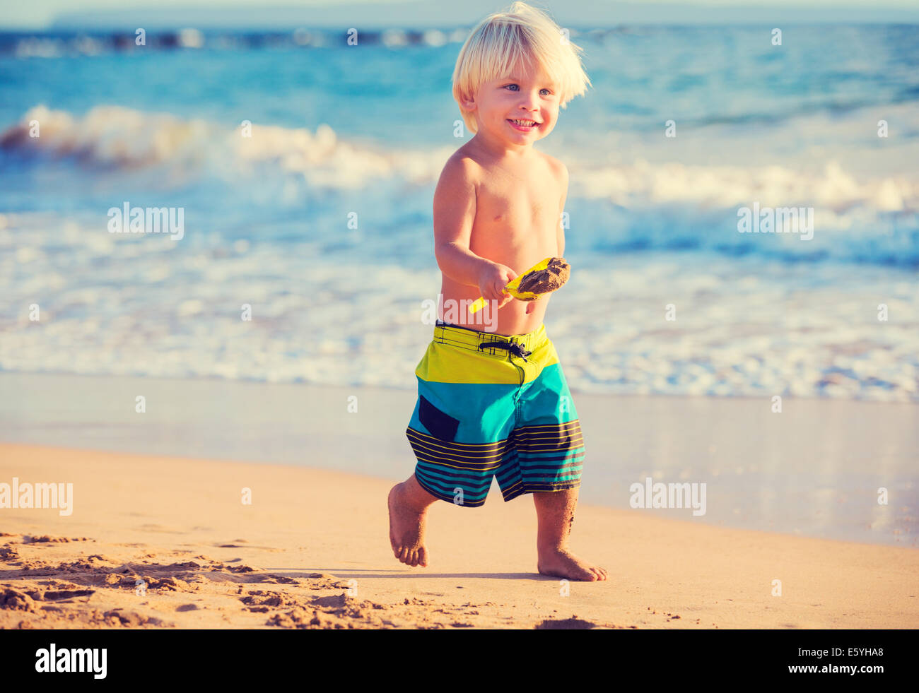 Happy young boy playing at the beach Stock Photo - Alamy