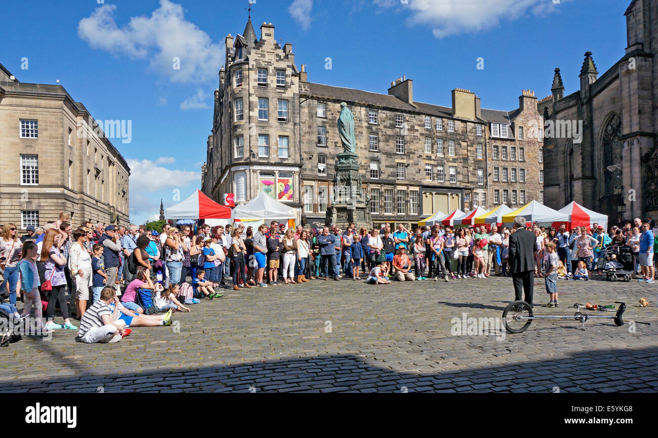 Performer surrounded by visitors to the Edinburgh Fringe Festival 2014 in W. Parliament Square Royal Mile Edinburgh Scotland Stock Photo