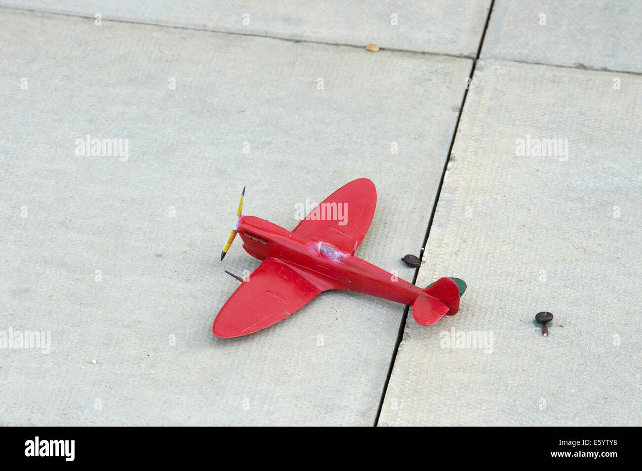 broken red toy spitfire landing gear torn off Stock Photo