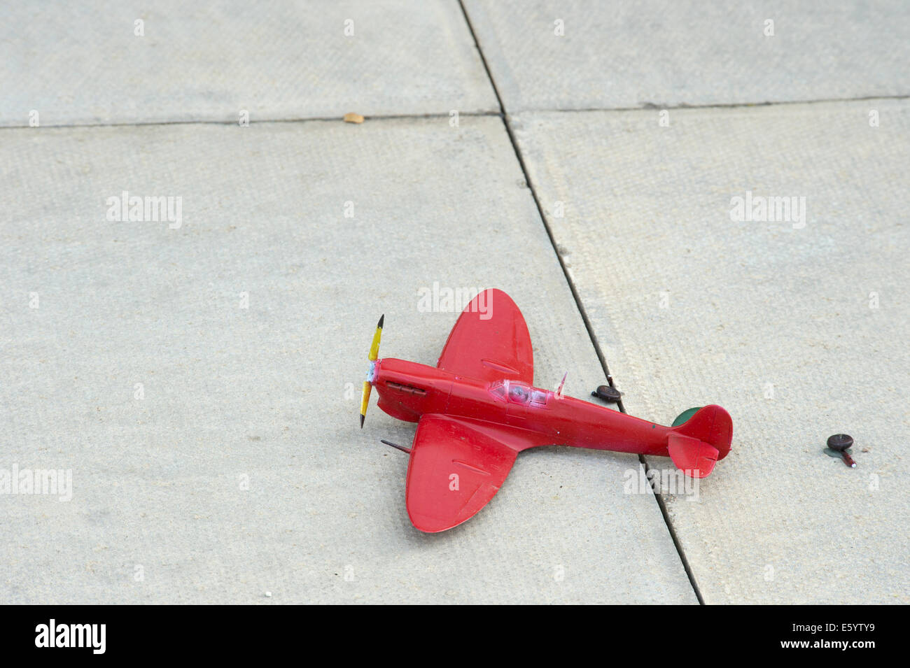 broken red toy spitfire landing gear torn off Stock Photo