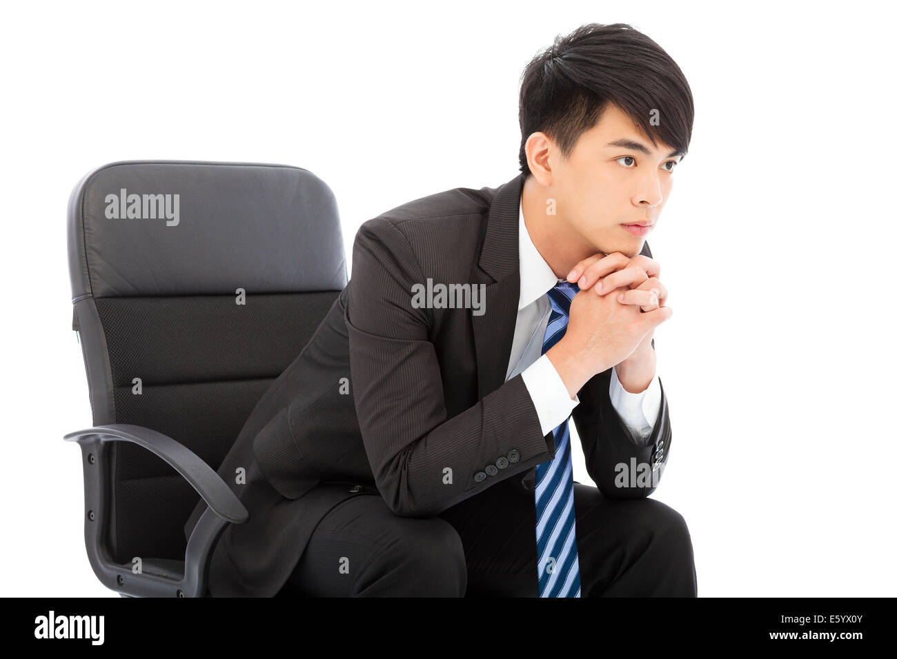 Young businessman thinking and sitting in a chair Stock Photo