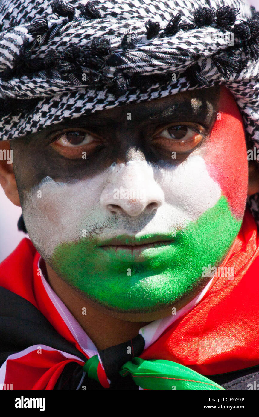 London, UK. 9th August, 2014.  His face painted in the colours of the Palestinian flag, one of up to 150,000 protesters marches towards a Hyde Park rally. Credit:  Paul Davey/Alamy Live News Stock Photo