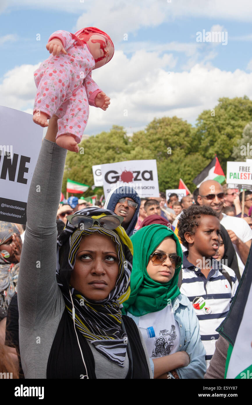 London, UK. 9th August, 2014.  A woman holds aloft a 'bloodstained' doll as up to 150,000 people take part in a march and rally in support of the people of Palestine. Credit:  Paul Davey/Alamy Live News Stock Photo