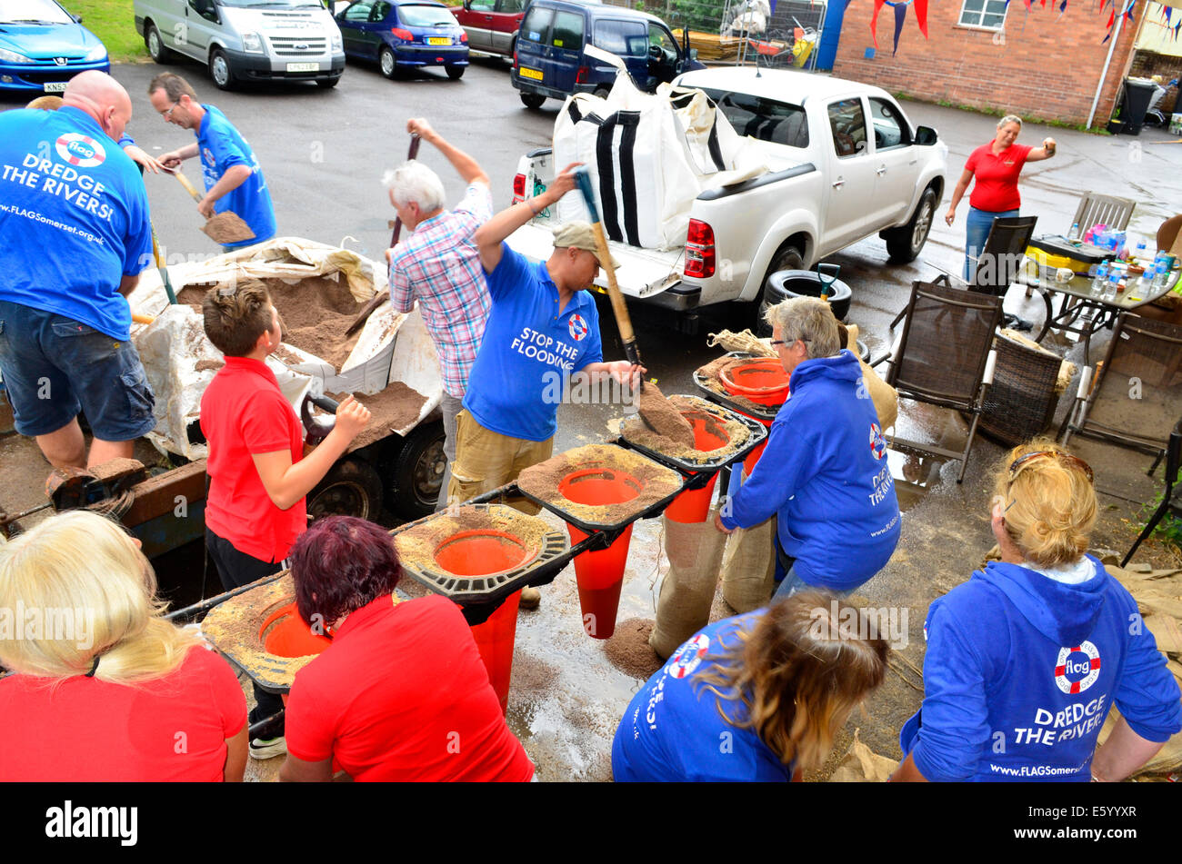 Burrowbridge, Somerset, UK. 9th August, 2014. UK weather: An Emergency call out for local helpers to make more Sandbags to be put in place around the bridge and along the Main Road opposite due to very bad weather forecast moving in.. TRAFFIC CONES with ends cut off help fill the sand bags Quicker as sand is poured in at the top. Credit: Robert Timoney/Alamy Live News Stock Photo