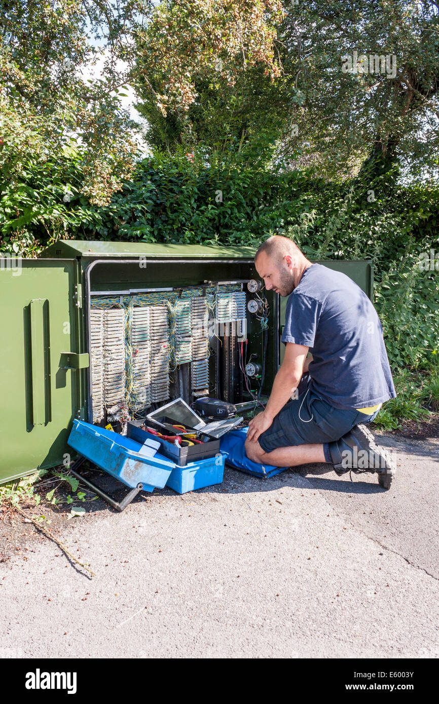 Engineer working for BT Openreach corrects broadband faults at a roadside terminal. Stock Photo