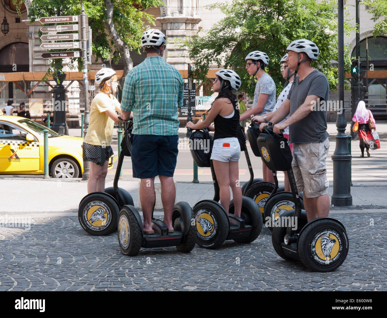 Young tourists on Segway (two-wheeled electric vehicle) with their guide in front of the Opera House, Budapest, Hungary Stock Photo