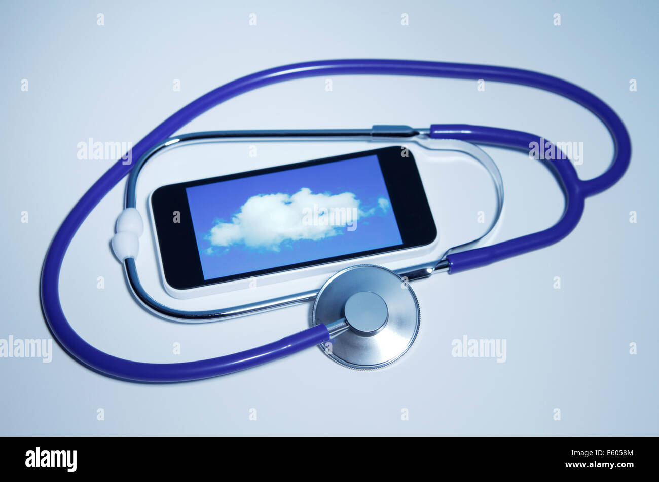 Cloud medicine Acoustic stethoscope and an Apple iPhone 5c that displays a cloud. All logos removed. Stock Photo