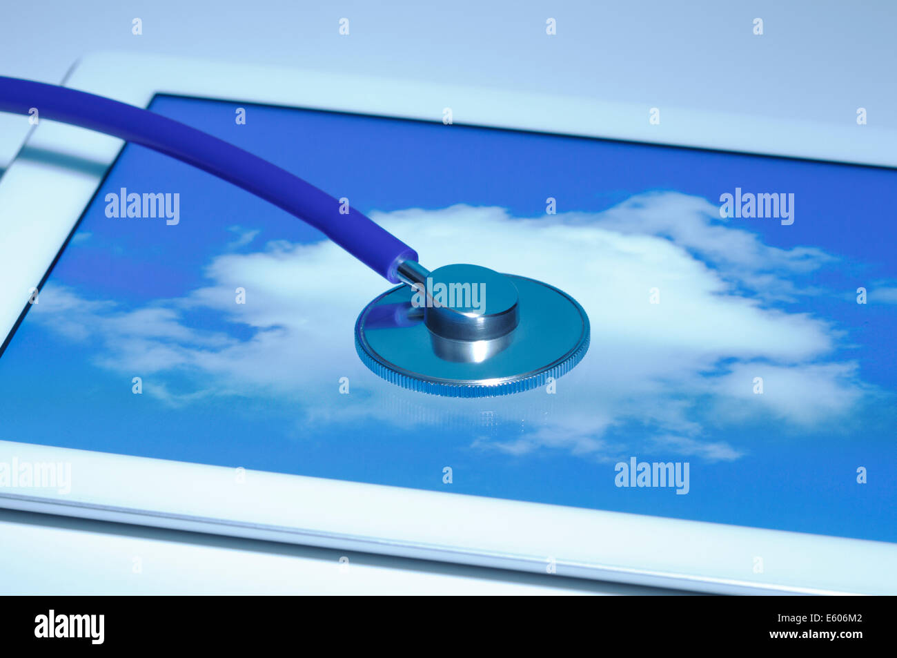 Cloud medicine Acoustic stethoscope and an Apple iPad 2 that displays a cloud. All logos removed. Stock Photo
