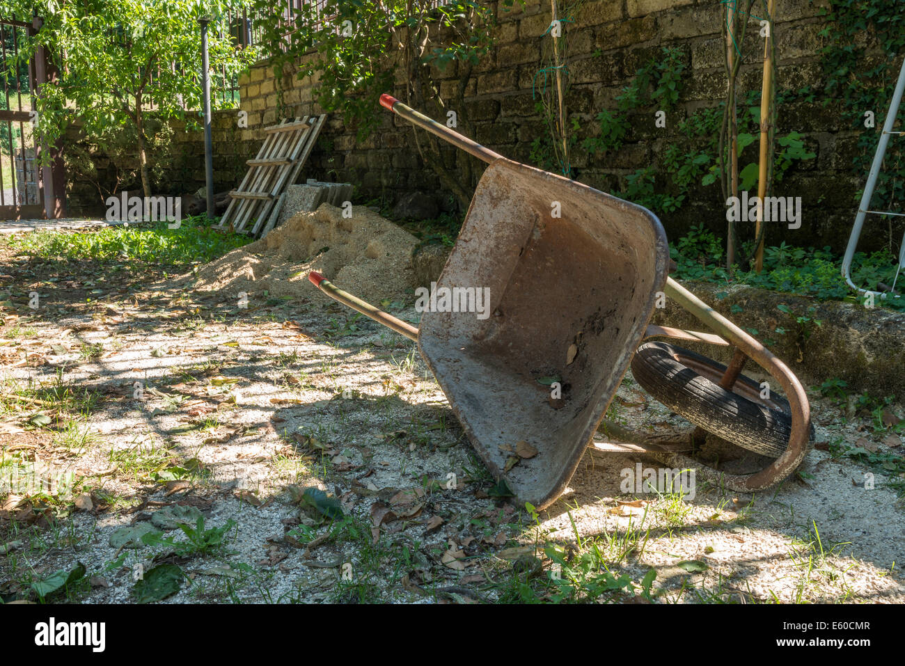 old and rusty wheelbarrow during garden work Stock Photo