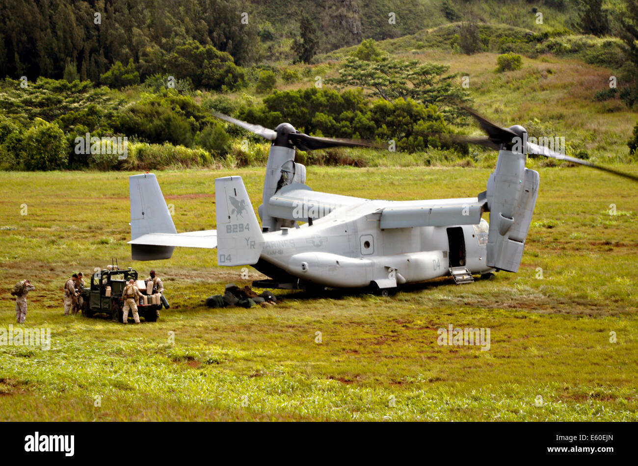 US Marines unload supplies from a MV-22 Osprey tiltrotor aircraft onto a ground unmanned support surrogate, a vehicle that can drive autonomously during experimental exercises as part of Rim of the Pacific July 11, 2014 at Kahuku Training Area, Hawaii. Stock Photo