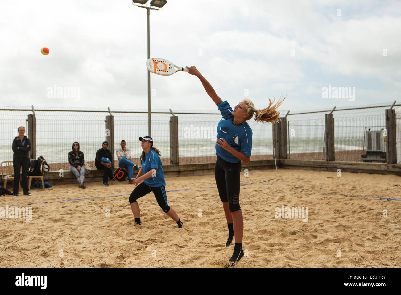 City of Brighton & Hove, East Sussex, UK. European Beach Tennis Championships 2014 Brighton at Yellow Wave, Madeira Drive, Brighton, Sussex, UK. European Beach Tennis Championships 2014 at Yellow Wave, Madeira Drive, Brighton, Sussex, UK. This image is of the women's doubles team from Israel competing in the the 3rd/4th place play off, despite the heavy winds coming in from the sea. David Smith/Alamy Live News Stock Photo