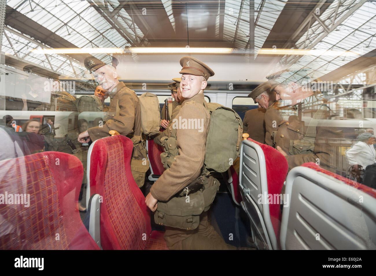 London, UK, UK. 10th Aug, 2014. The Khaki Chums, a regiment of living historians, re-enacted the journey of WW1 soldiers arriving at Waterloo Station in London, sleeping on railway land overnight before departing on a train bound for Southampton. The regiment performed a march through the station to pay their respects to those who stood in their shoes a century ago. The re-enactment was part of the launch of an exhibition detailing the vital role Britain's railways and staff played in the Great War. Pictured: Living historian troops board the Southampton train at Waterloo Sta Stock Photo