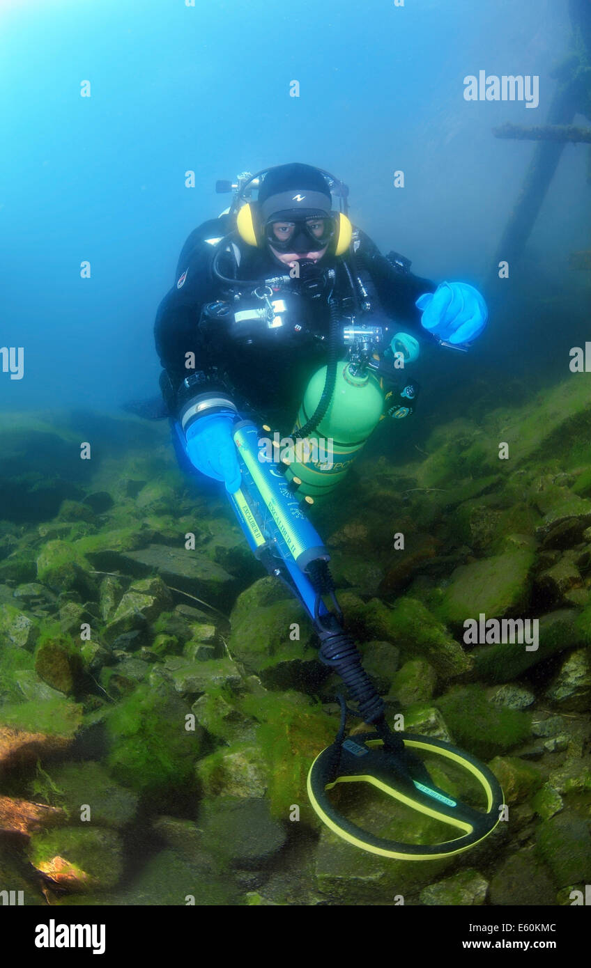 Diver with the metal detector searching for underwater treasure near to the wrack railway carriage, lake Baikal, Siberia, Russia Stock Photo