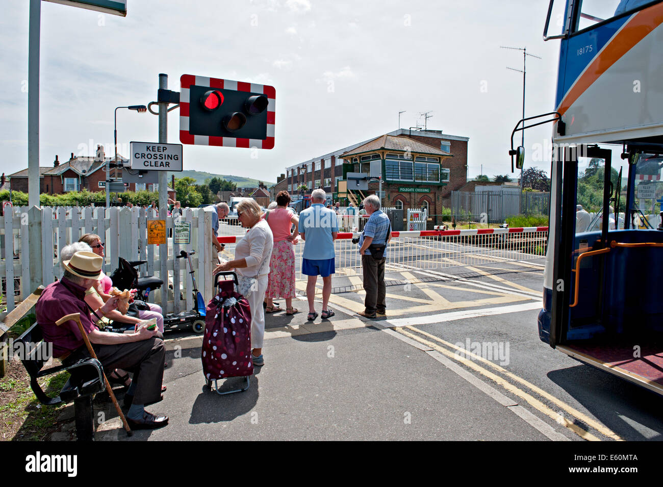 Pedestrians and traffic wait at the railway crossing at Polegate Sussex. UK Stock Photo