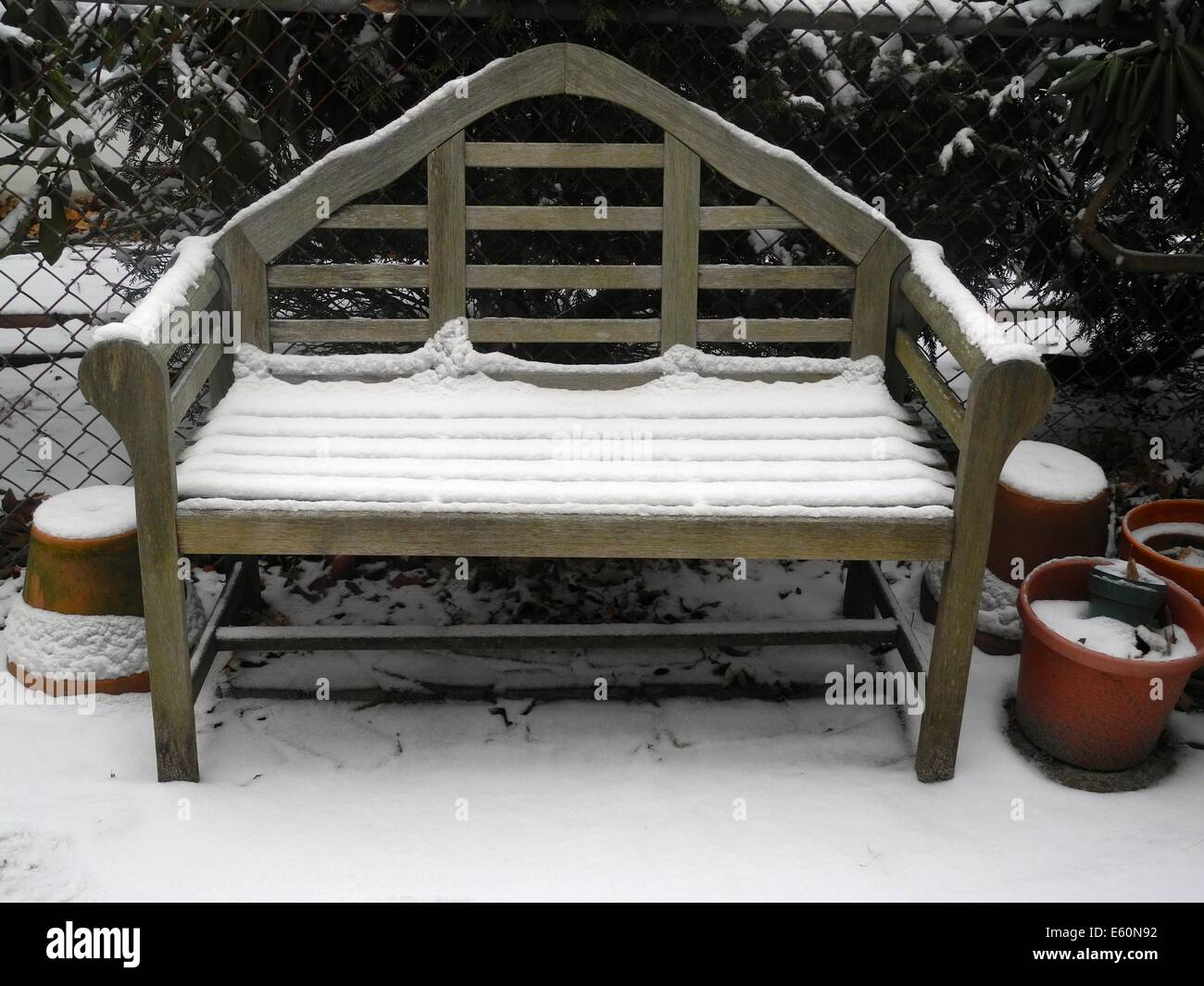 A Snow Covered Garden Bench The Bench And Garden Pots Are Covered