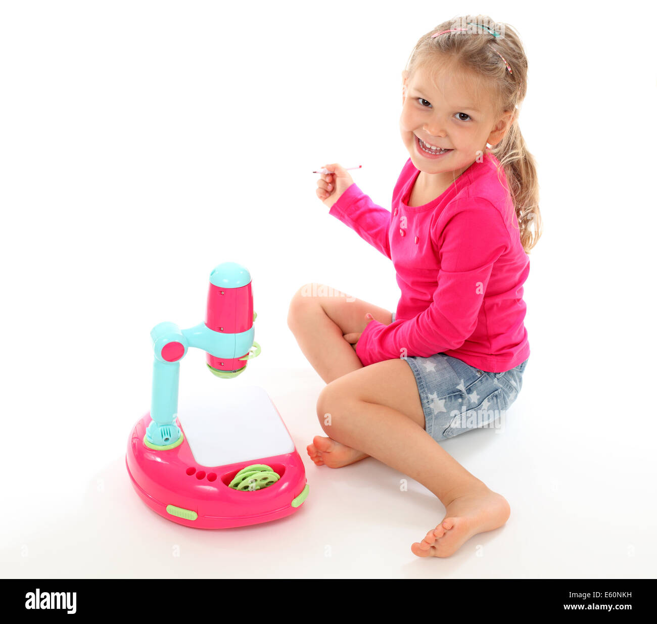 Little girl playing with a toy projector. Isolated over white background Stock Photo