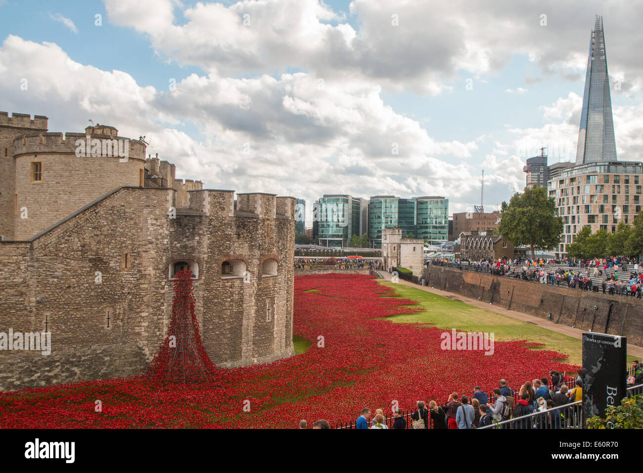 General view of the moat of the Tower of London with the poppies, the 'weeping window', the Shard and visitors Stock Photo