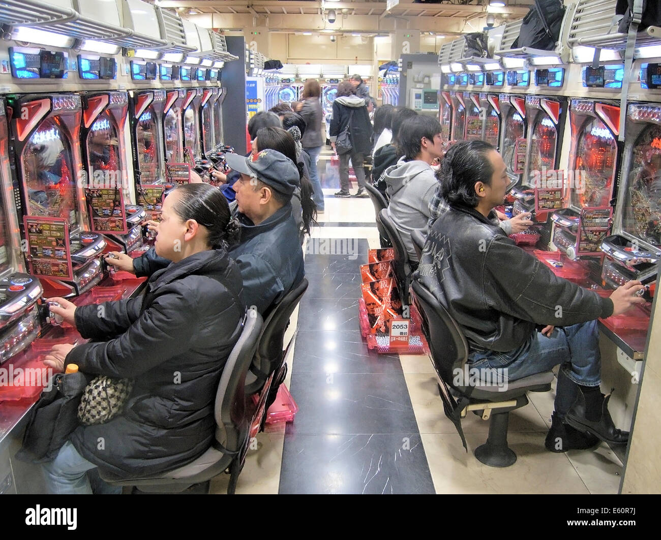Tokyo, Japan - March 23, 2009: Men gambling on Pachinko slot machines in a Pachinko arcade hall in Tokyo. Stock Photo