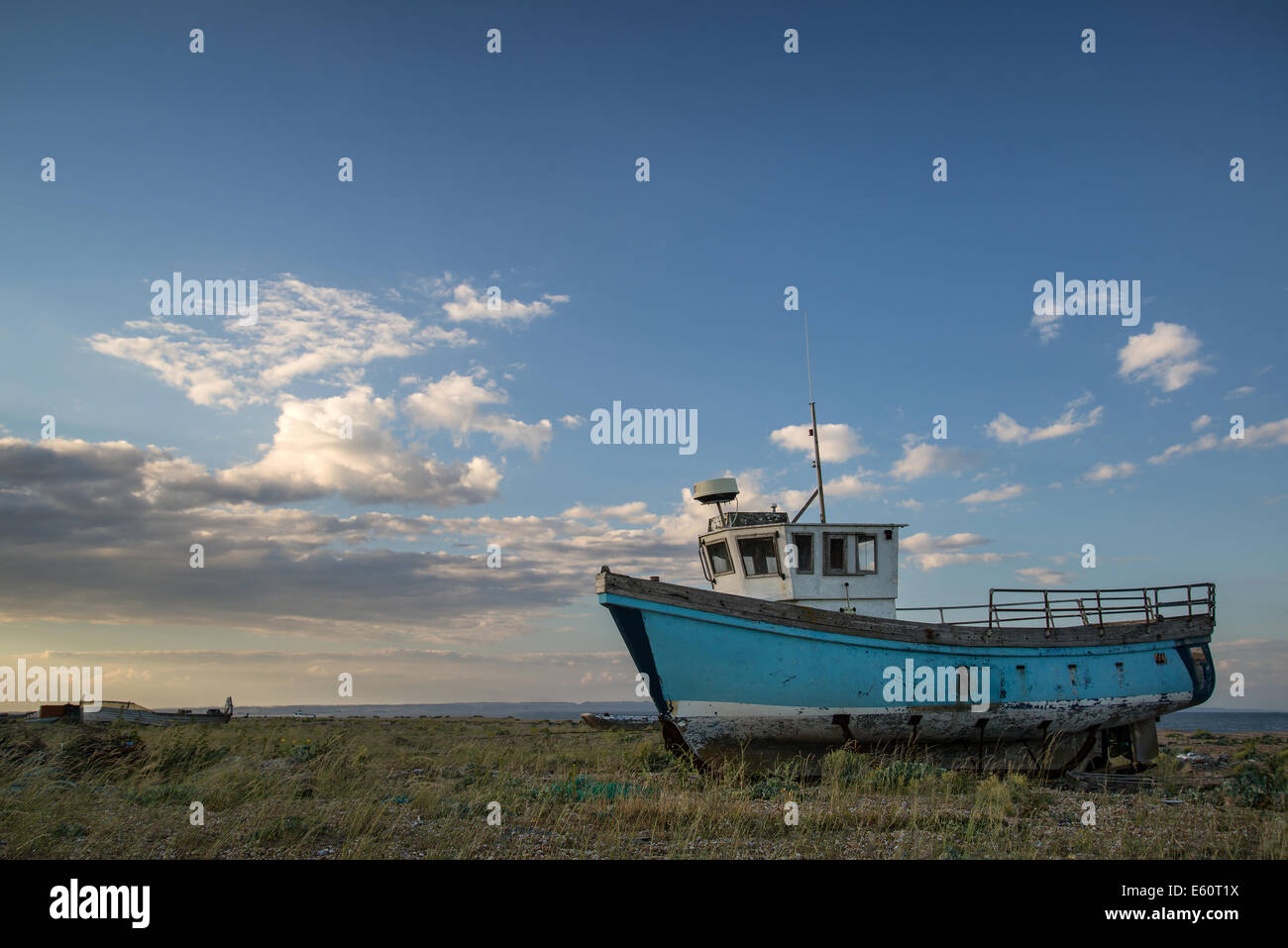 Abandoned fishing boat on shingle beach landscape at sunset Stock Photo ...