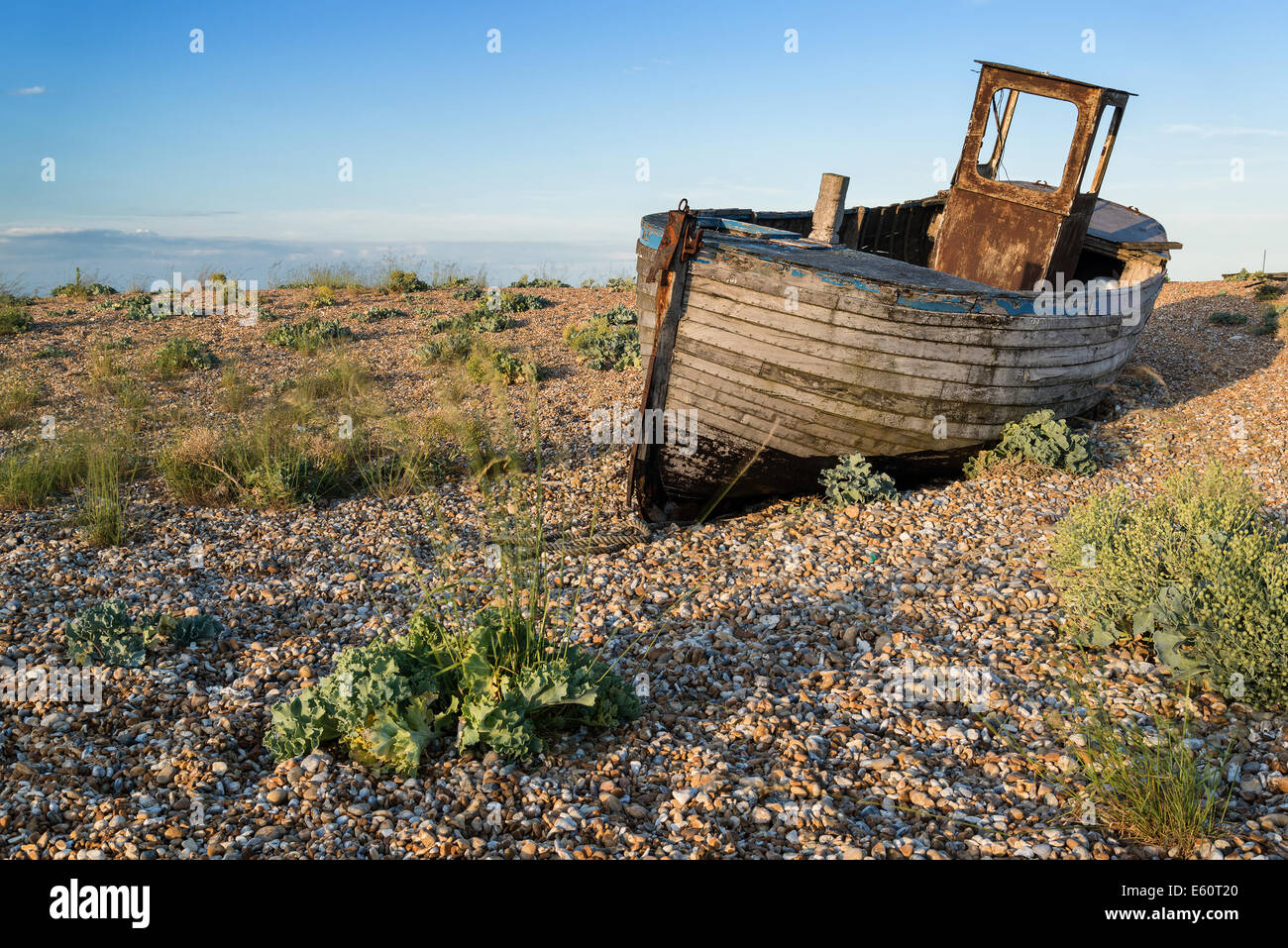 Abandoned fishing boat on shingle beach landscape at sunset Stock Photo ...