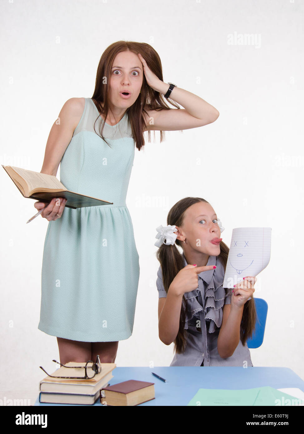 Teacher standing at desk behind which sits student who drew a funny ...