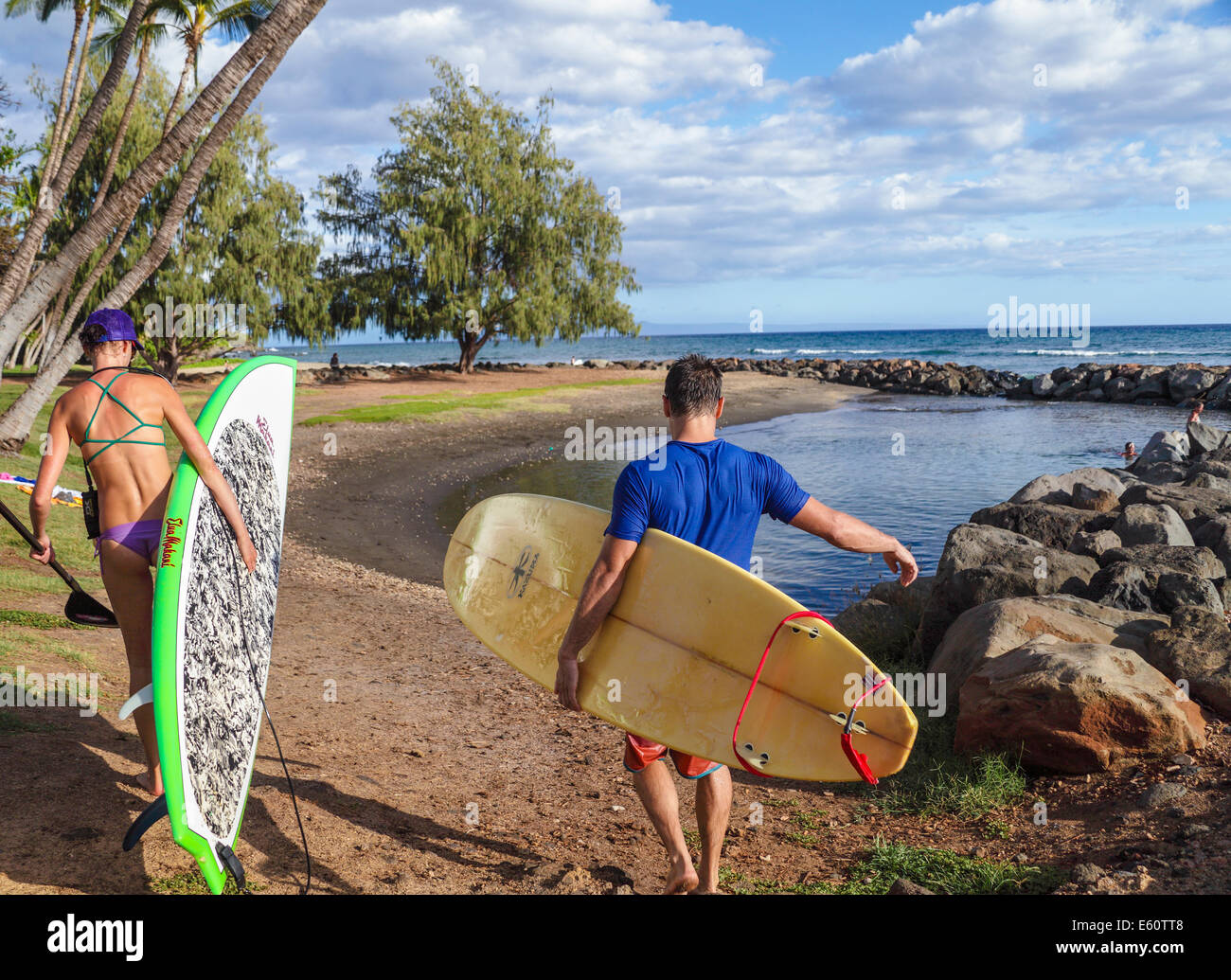 Couple with SUP and surfboard at Launiupoko State Wayside Park in Lahaina, Maui Stock Photo