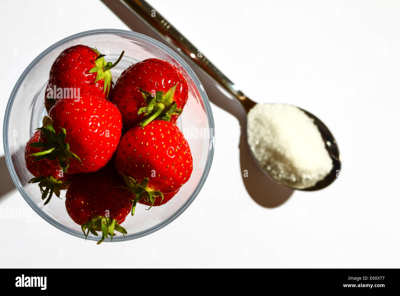 Strawberries in a glass and a spoonful of sugar Stock Photo - Alamy