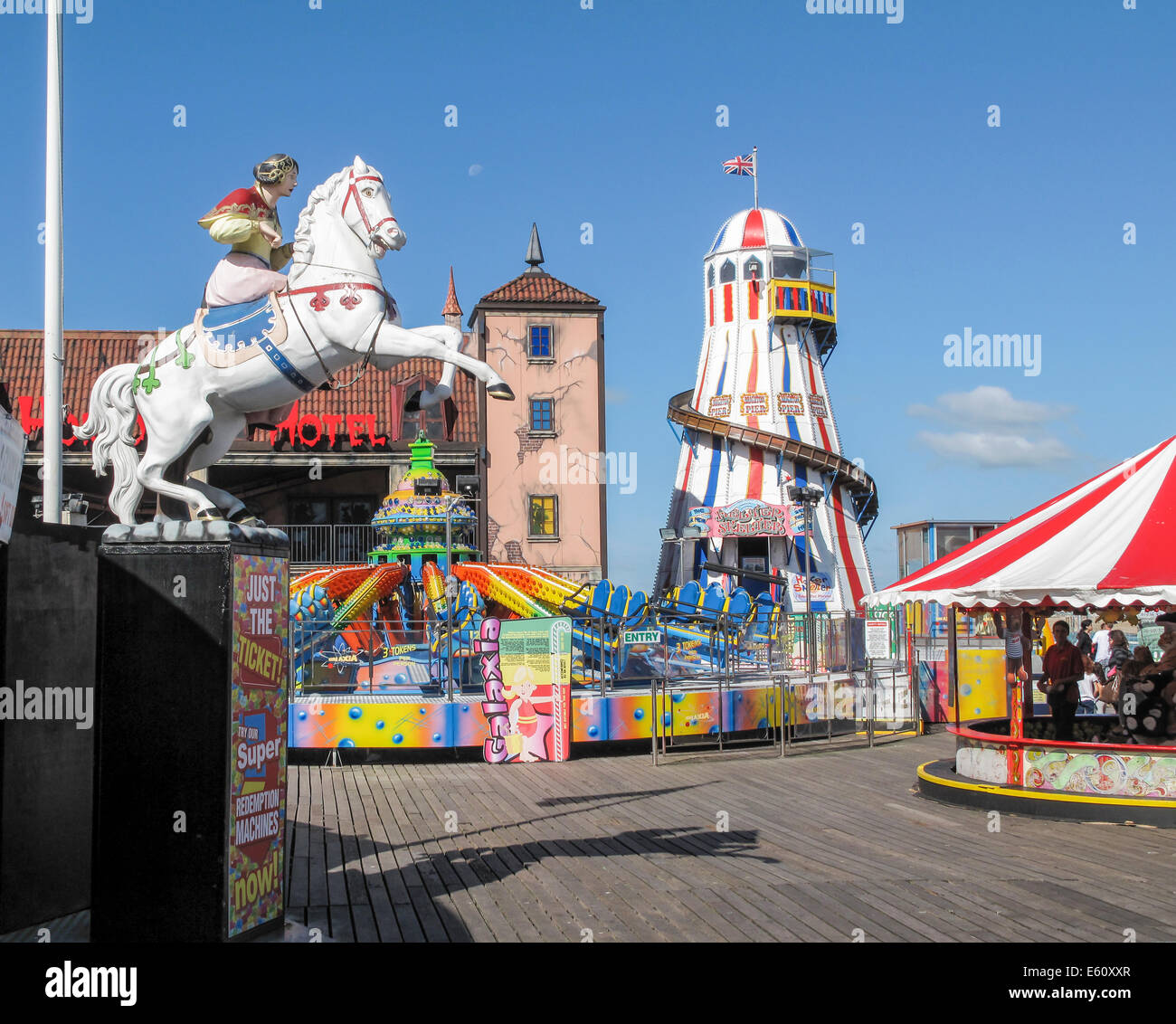South coast sightseeing: Helter skelter and colourful fairground attractions at the funfair on Brighton Pier popular for family holidays in summer Stock Photo