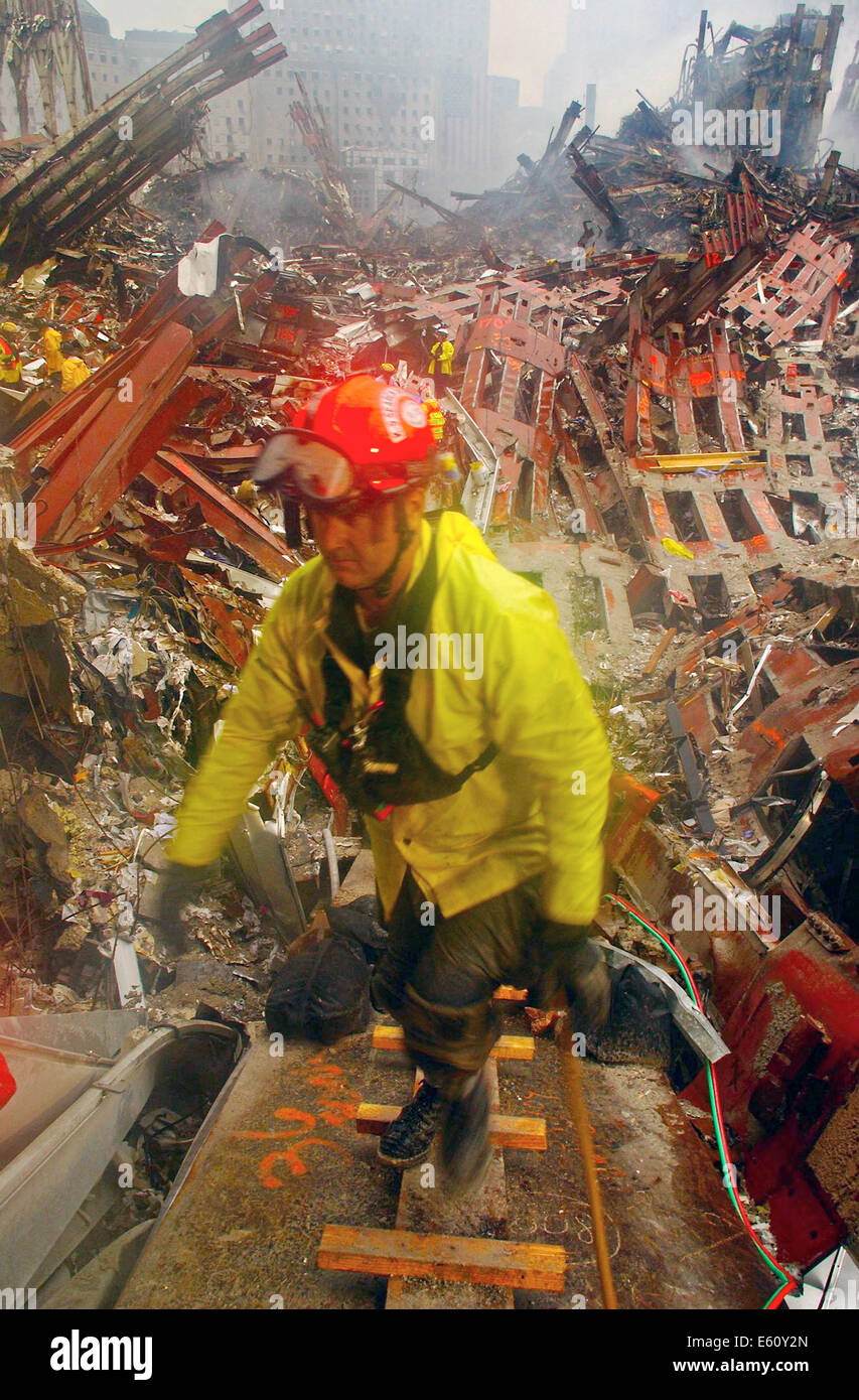 A rescue workers emerges from the pile of rubble amongst the wreckage of the World Trade Center in the aftermath of a massive terrorist attack which destroyed the twin towers killing 2,606 people September 21, 2001 in New York, NY. Stock Photo
