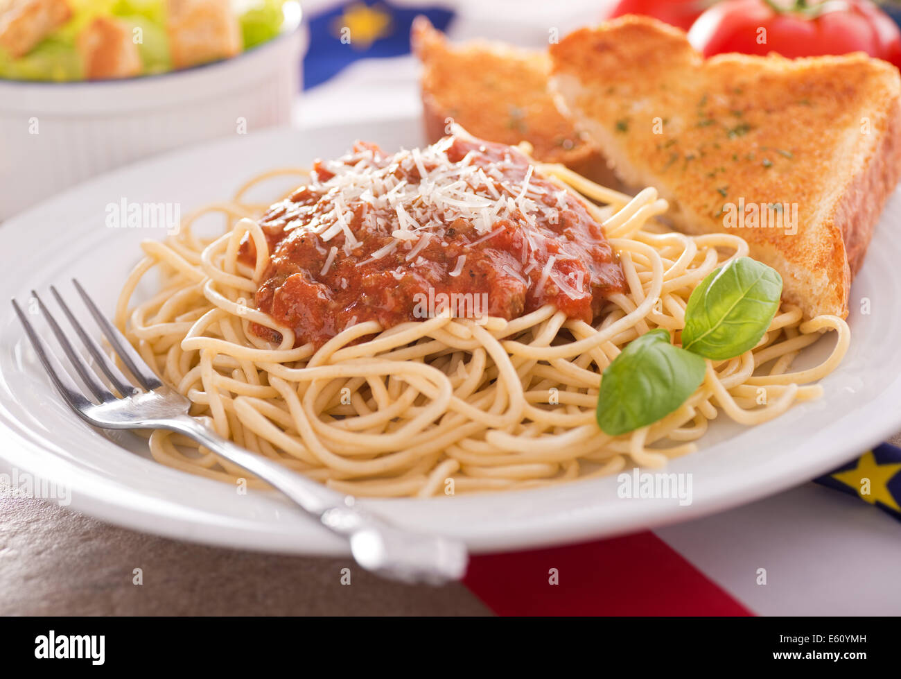 Homemade spaghetti with meat sauce, garlic bread, and caesar salad. Stock Photo