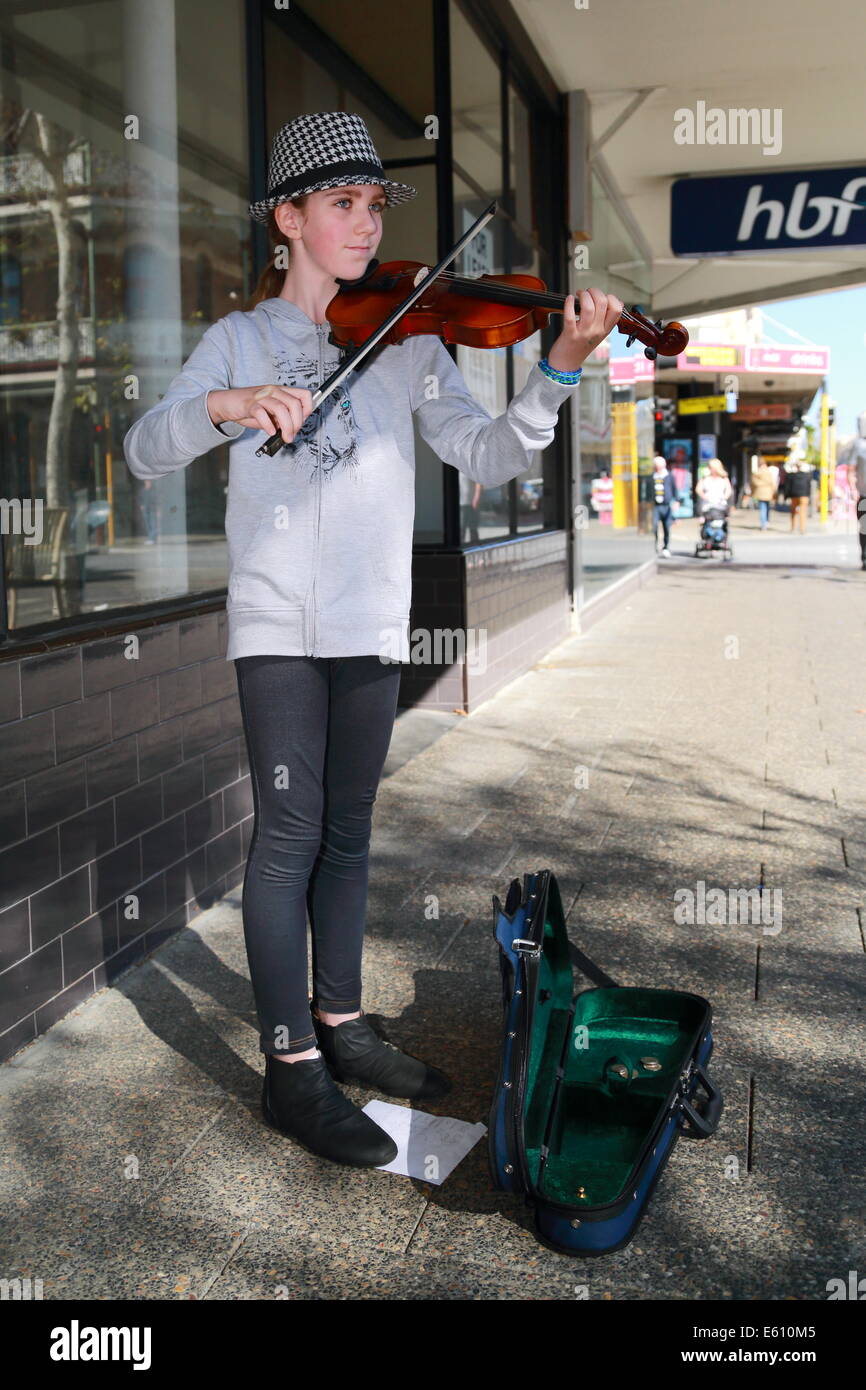 A young girl is busking with her violin in Fremantle, Western Australia. Stock Photo