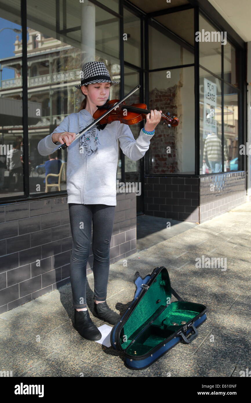 A young girl is busking with her violin in Fremantle, Western Australia. Stock Photo