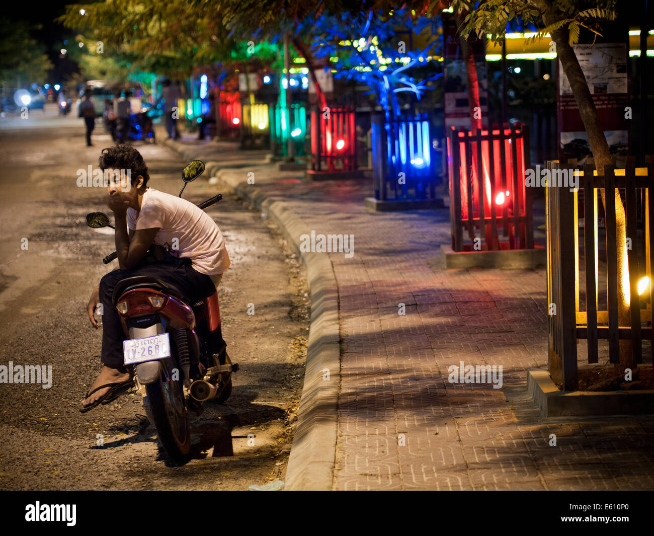 A view of a Cambodia teen sitting on his motorcycle on a street in Siem Reap, Cambodia. Stock Photo