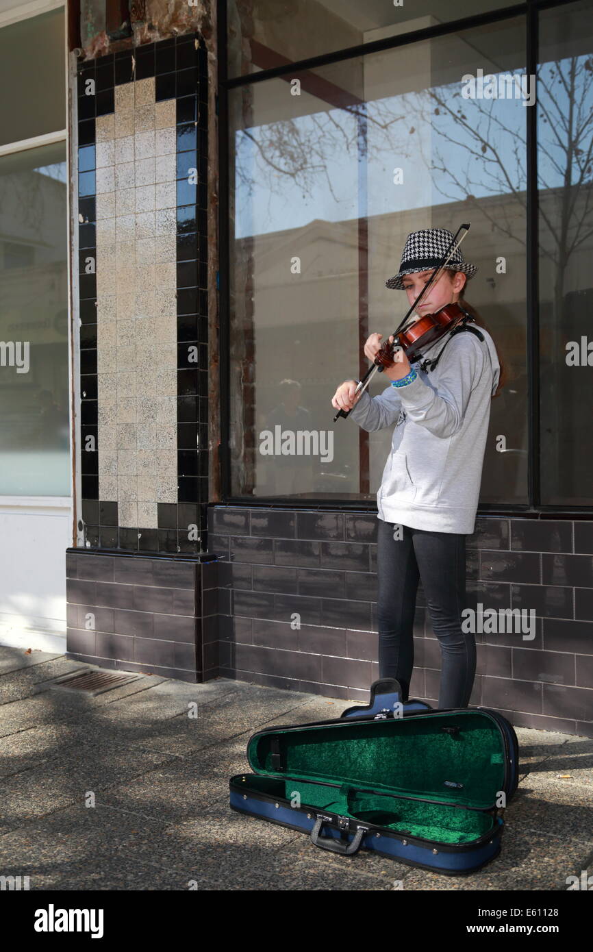 A young girl is busking with her violin in Fremantle, Western Australia. Stock Photo