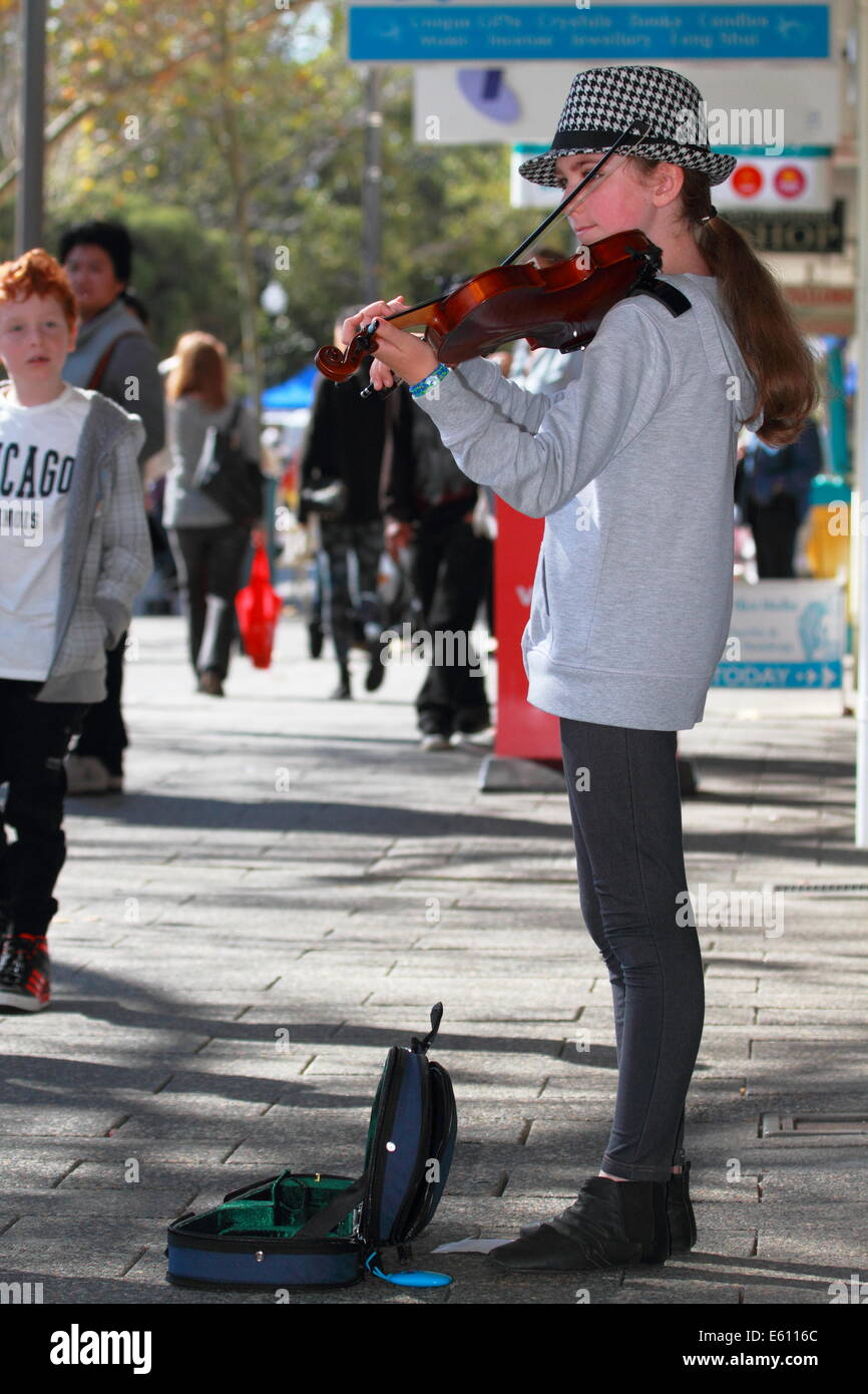 A young girl is busking with her violin in Fremantle, Western Australia. Stock Photo