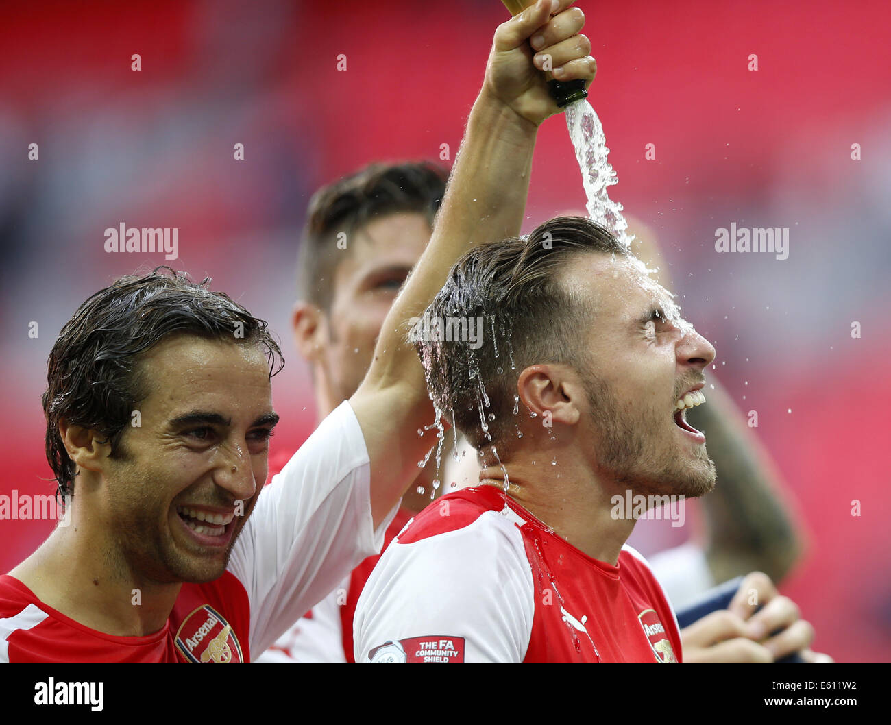 London, UK. 10th Aug, 2014. Mathieu Flamini(L) of Arsenal celebrates by spraying champagne towards his teammate Aaron Ramsey after the Community Shield match between Arsenal and Manchester City at Wembley Stadium in London, Britain on Aug. 10, 2014. Arsenal won 3-0. Credit:  Wang Lili/Xinhua/Alamy Live News Stock Photo